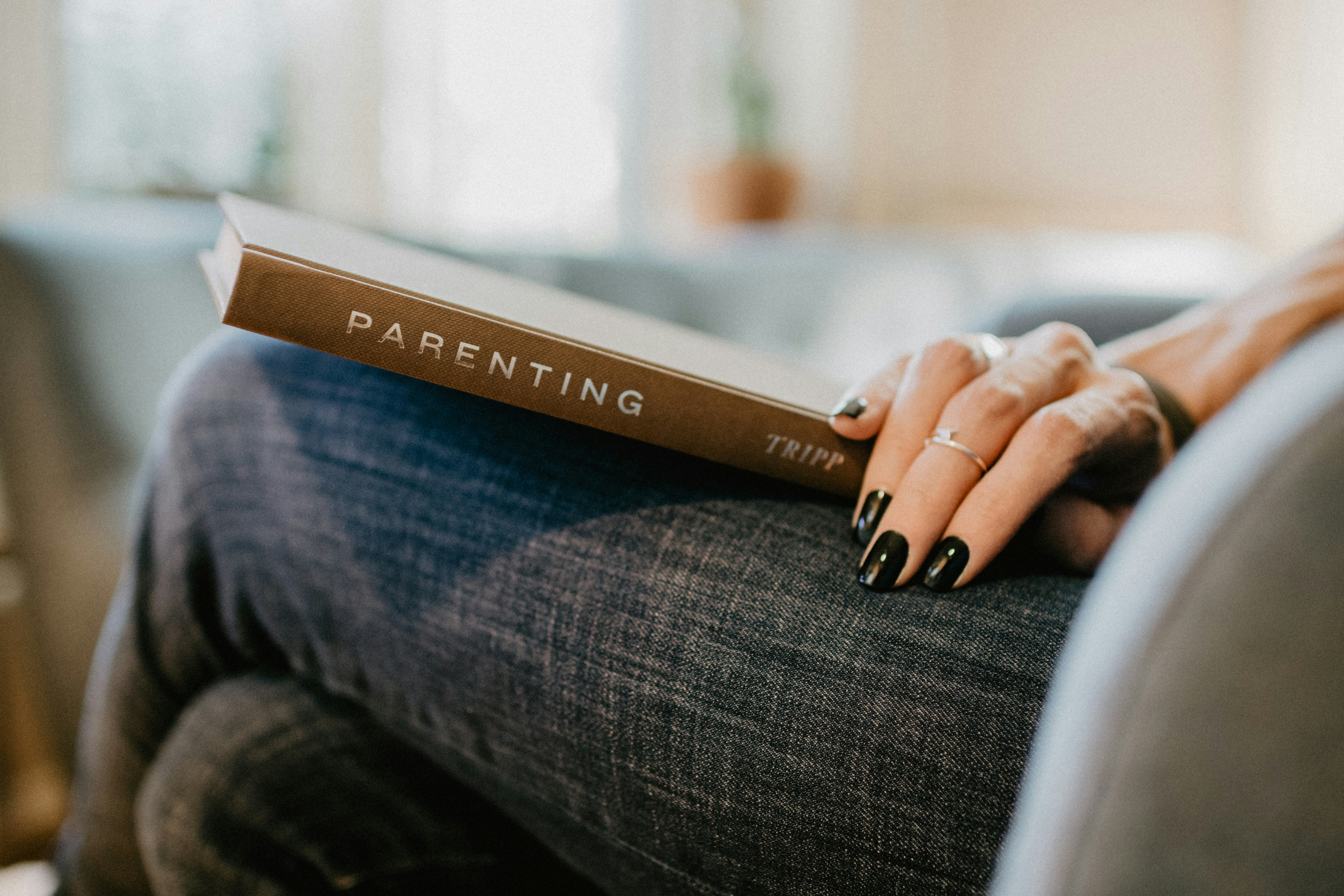 Parenting book resting on a lap, a quiet moment of reflection